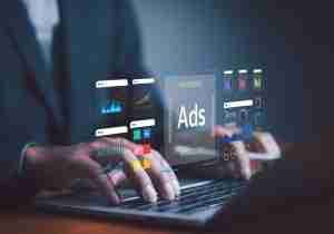 Boston business owner comparing Google Ads and Local Services Ads performance dashboards on laptop